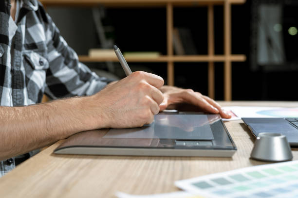 istock Young adult man working with graphic tablet in office 1190798590