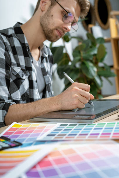 istock Young adult retoucher working with graphic tablet in office 1190798622