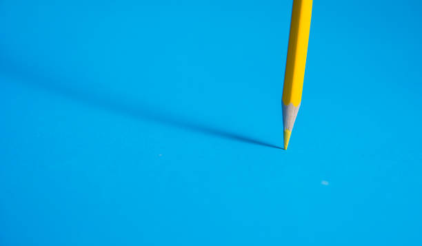 istock vibrant yellow color pencil nib in focus on blue background with soft shadow effect 1190801130