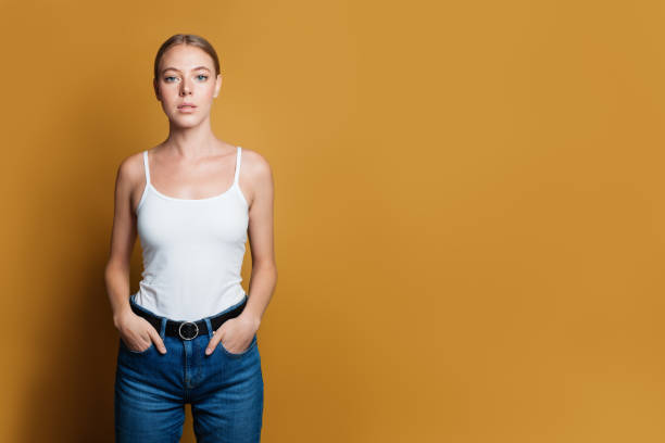 istock Confident young woman standing on yellow background 1190801238