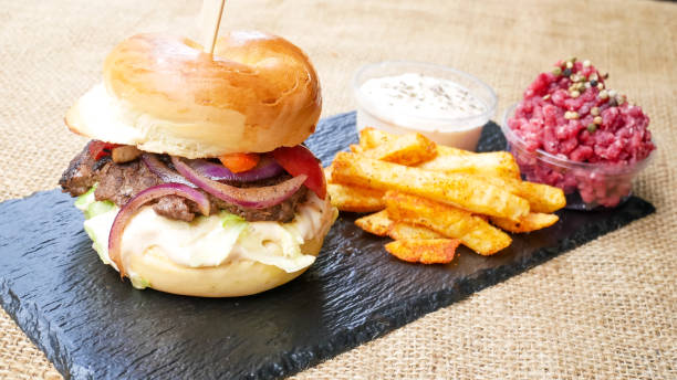 istock Meaty hamburger and fries on a table 1190802607