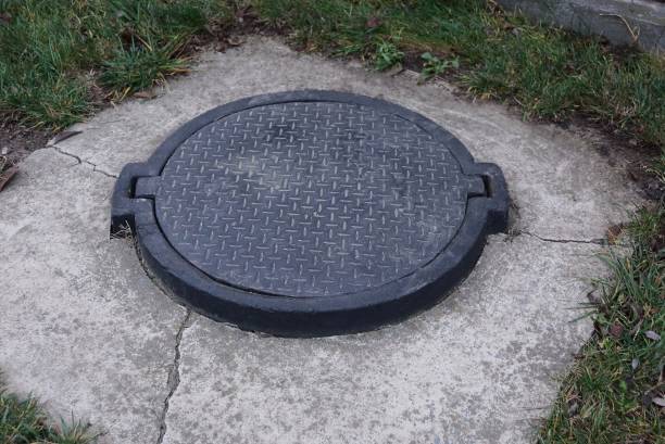 istock black iron hatch on the sewer in gray concrete 1190803295