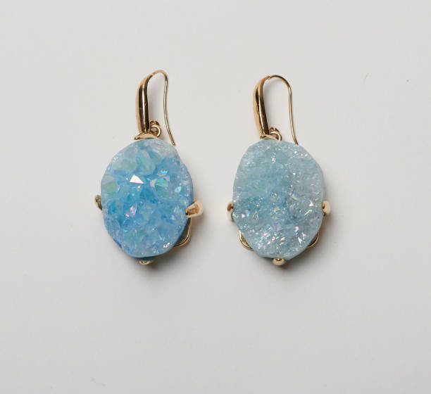istock Golden loop earrings with beautiful blue stone studs with white background 1190804033