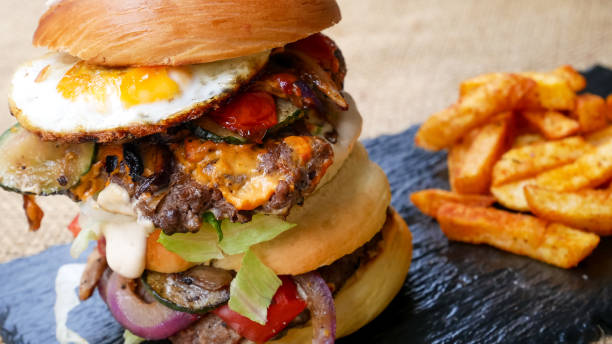 istock Meaty hamburger and fries on a table 1190806772