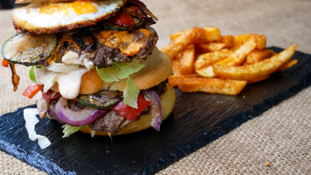istock Meaty hamburger and fries on a table 1190806776