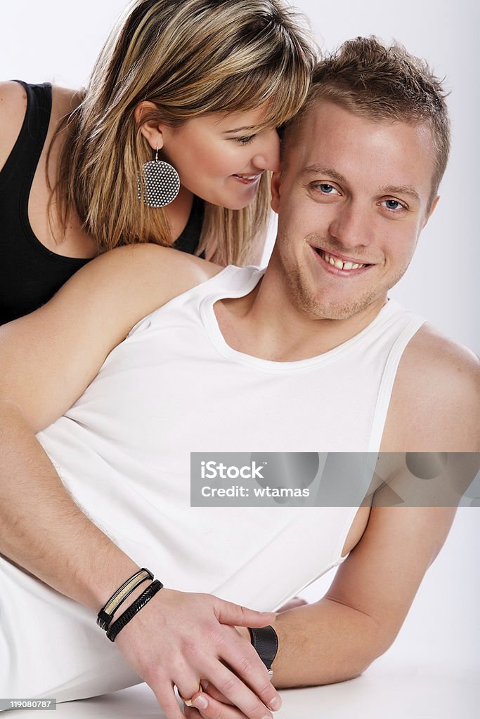 Jovem casal feliz sentado em fundo branco - Foto de stock de Abraçar royalty-free