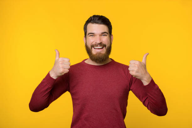 istock beard beard beard bearCheerful bearded guy, standing over yellow background and showing thumbs upd beard beard beard 1190809345