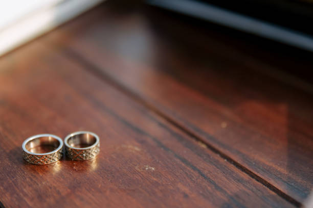 istock Wedding rings on a wooden background in daylight 1190813803
