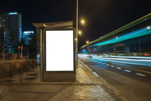 Photo of Blank bus stop with billboard at night