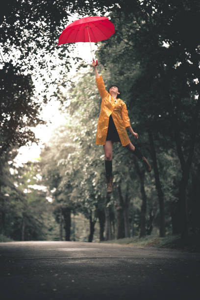 istock Woman holding umbrella on wind 1190817709