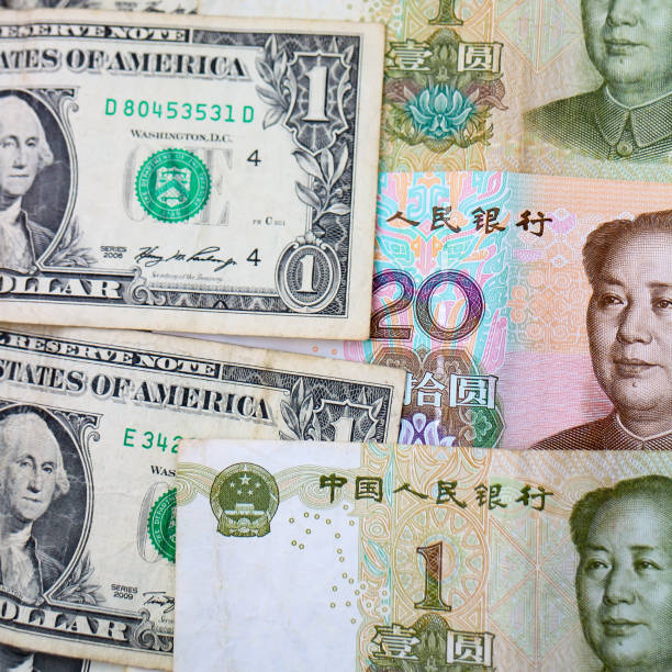 istock US Dollars and Chinese Yuan banknotes 1190821327