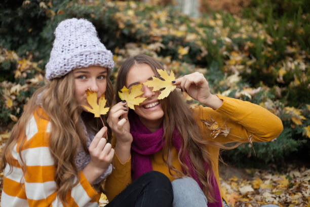 istock Girlfriends having fun in the autumn leaves 1190823220
