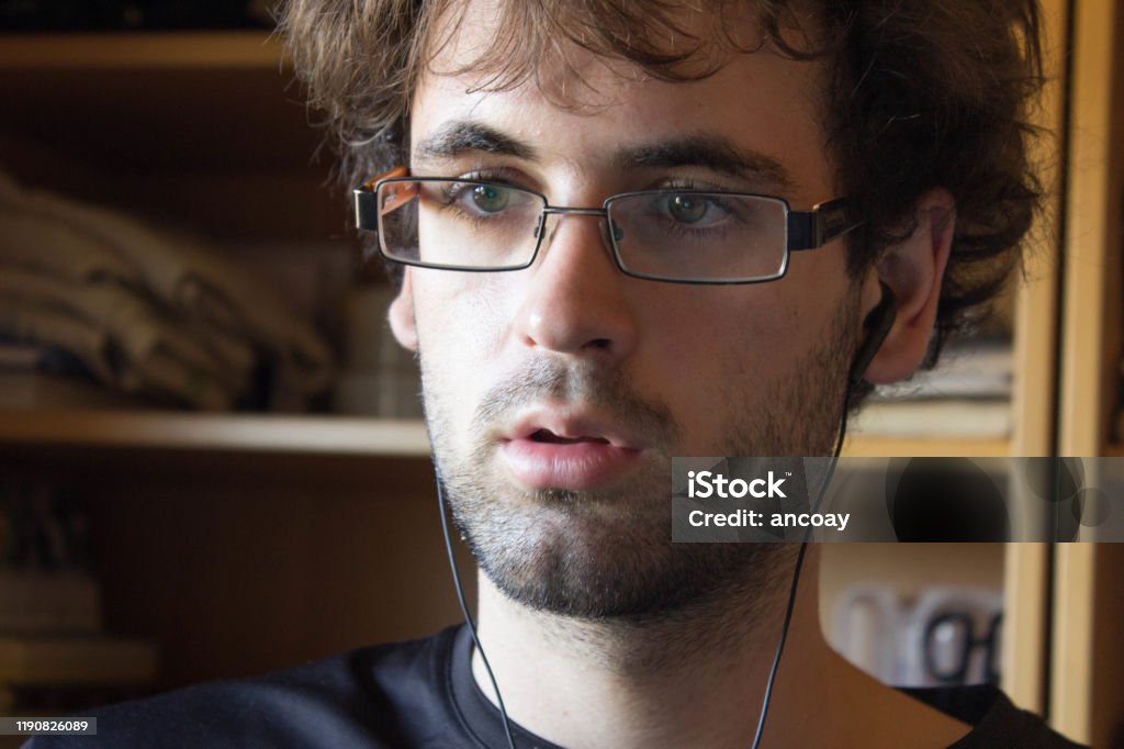 Young White Boy With Curly Hair And Glasses In Studio Position Listening To  Music Stock Photo - Download Image Now - iStock