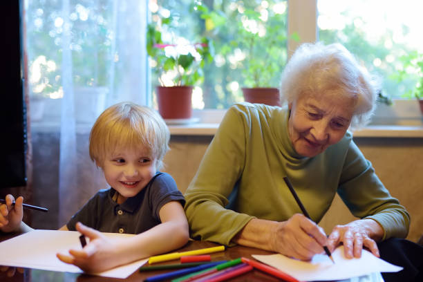 starsza babcia pomaga małedziecko odrabia pracę domową. babcia i wnuk rysunek razem. - grandmother reading child grandson zdjęcia i obrazy z banku zdjęć