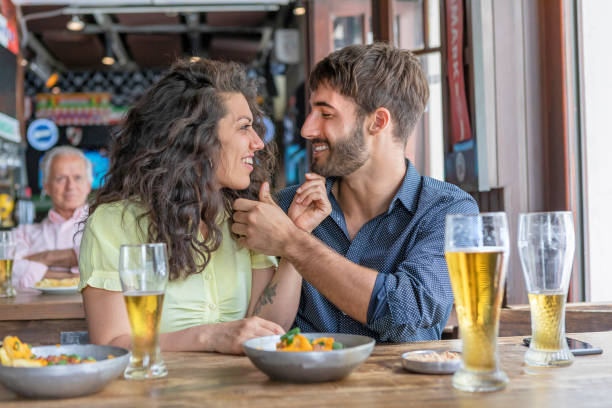 istock Young couple flirting at pub drinking beer 1190826464