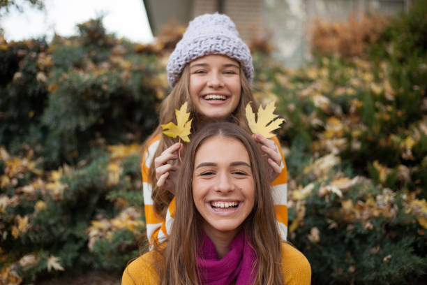istock Girlfriends having fun in the autumn leaves 1190827853