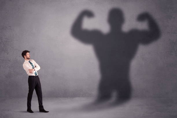 istock Business man looking at his own strong fit shadow concept 1190829108