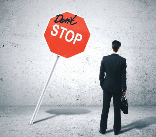 istock Businessman looking on dont stop sign 1190829372