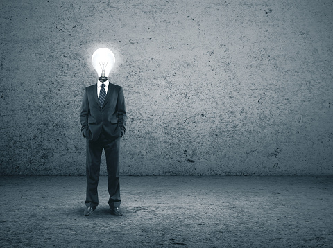 Businessman in suit with lightbulb instead of a head. Business idea concept.