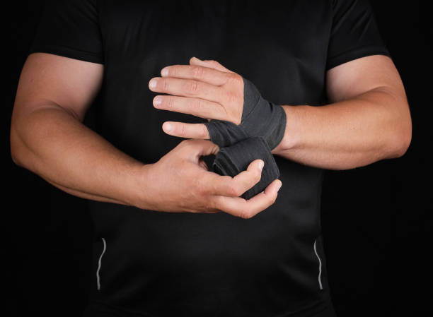 istock athlete stand in black clothes and wrap his hands in textile elastic bandage 1190829510