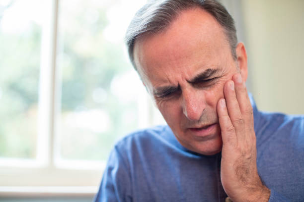Mature Man Suffering With Toothache And Rubbing Painful Tooth Mature Man Suffering With Toothache And Rubbing Painful Tooth disaster stock pictures, royalty-free photos & images