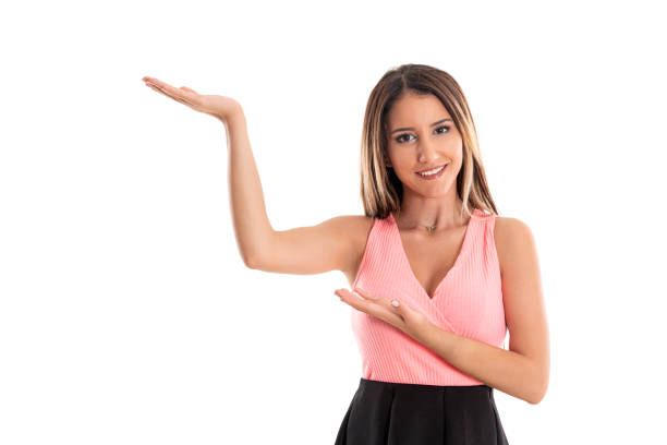 Happy young woman in pink top showing empty copyspace