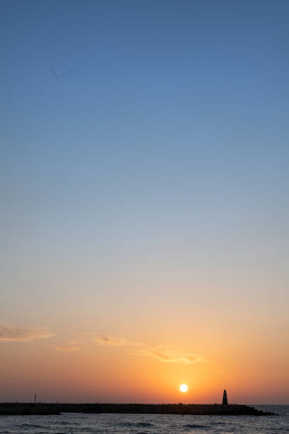 イスラエルのテルアビブの灯台に沈む地中海夕日。 - sailboat sunset tel aviv sea ストックフォトと画像