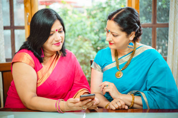 istock Two women share a smartphone. 1190836740