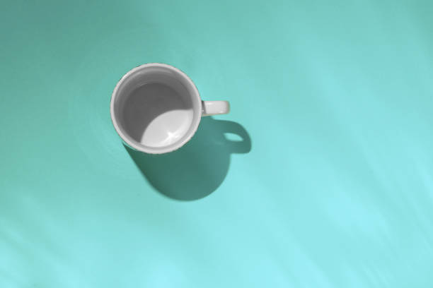 istock Empty tea cup on blue paper background. Coffee mug from above. Minimal concept. Long shadow. Flat lay, top view. 1190838224