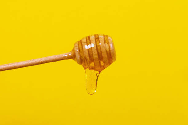 istock Honey dripping from honey dipper 1190844373
