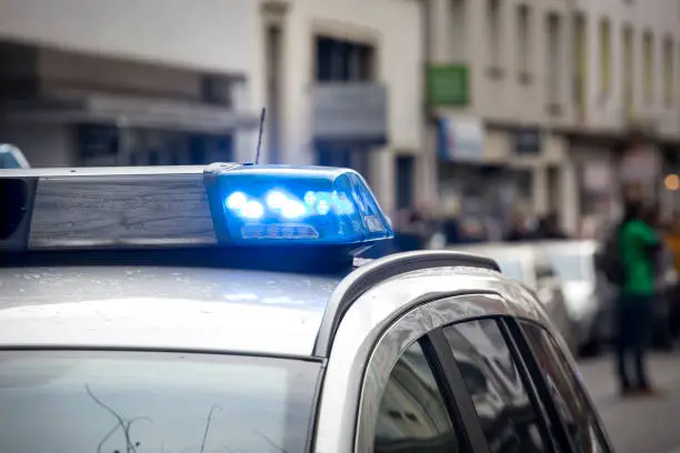 Police car at the place of action - flashing bluelight, siren