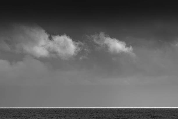 белые облака над уодден морем с полосой белого света на горизонте в черно-белом - sea black and white horizontal horizon over water стоковые фото и изображения