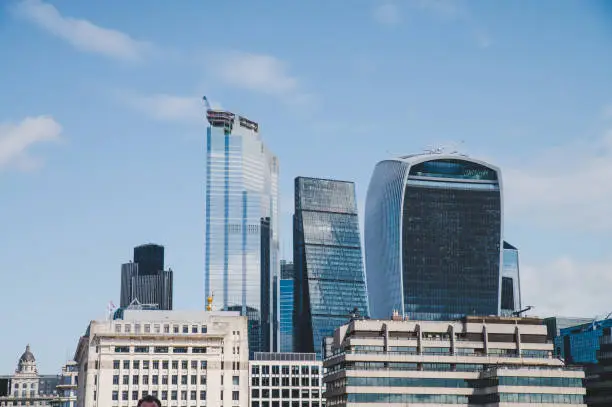 Photo of London, England - The bank district of central London with famous skyscrapers and other landmarks at sunset with grey sky - UK