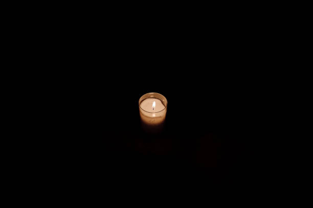 istock little single candle in the dark - hope concept- 1190852031