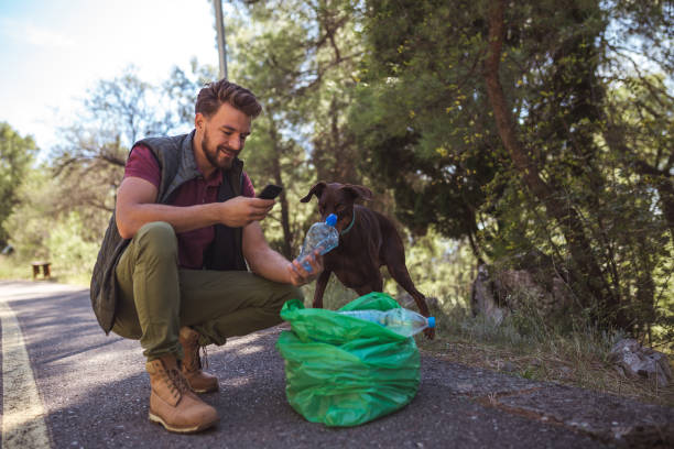 istock Young volunteer man is sorting plastic waste via mobile app with his friend in the forest 1190852477