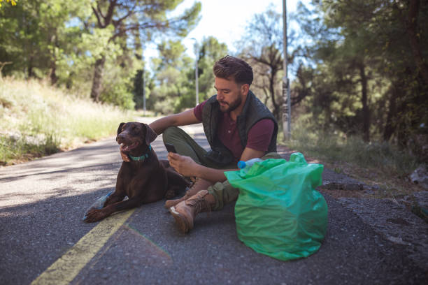 istock Young volunteer man is sorting plastic waste via mobile app with his friend in the forest 1190852744