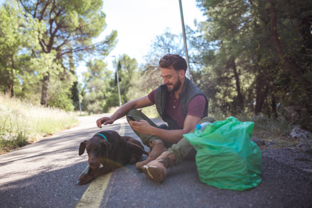 istock Young volunteer man is sorting plastic waste via mobile app with his friend in the forest 1190852762