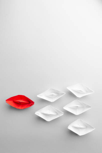 istock Leadership concept using red paper ship among white. From above. text space 1190855175