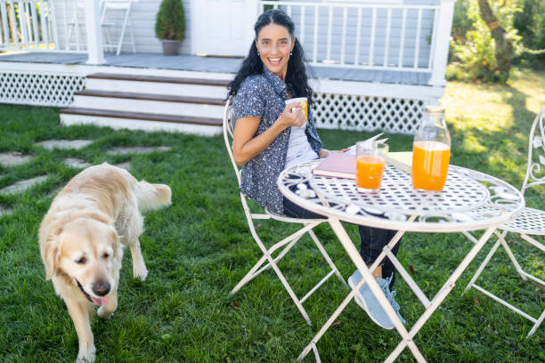 istock Woman sitting in back yard and drinking orange juice, resting 1190855485