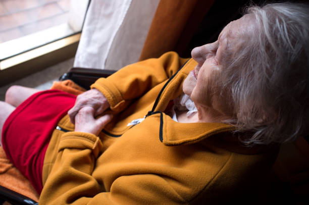 old woman looking in a window - fotografia de stock