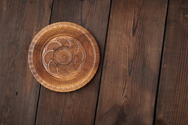 istock empty round brown carved decorative plate standing on a wooden background 1190858037