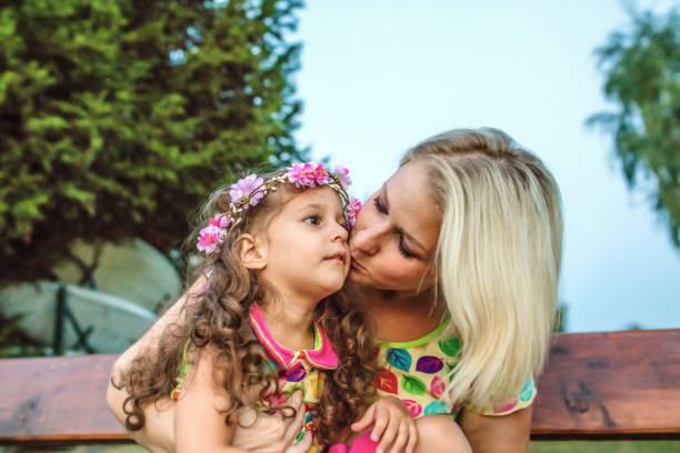 istock Cheerful mother with her daughters enjoying on dock by lake 1190858125