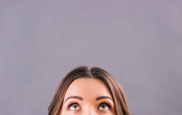 Photo of Half face of adorable woman's face looking up above copy space
