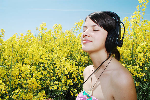 A happy young teeanage girl listening to music over her headphones