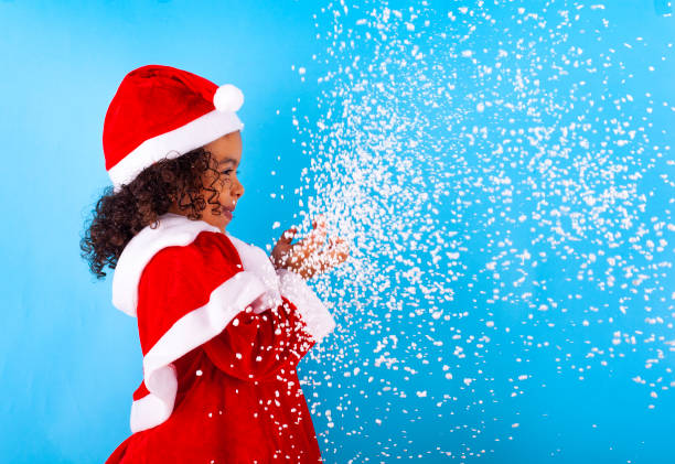 산타 클로스 모자 불고 눈송이에 아프리카 계 미국인 어린 소녀 - fake snow santa claus christmas christmas decoration 뉴스 사진 이미지