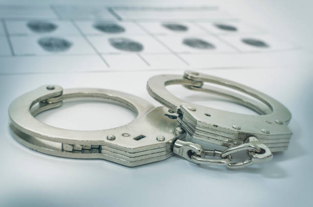 Police Handcuffs on fingerprints crime page file stock photo