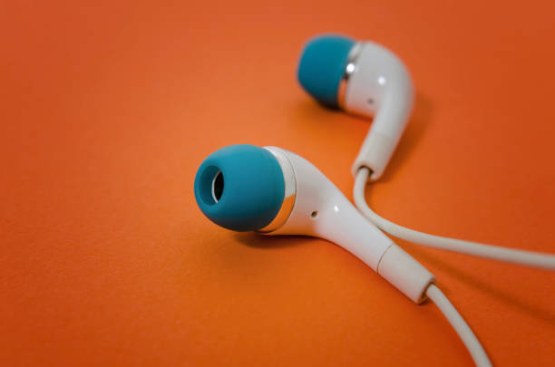 istock Earphones on orange background 1190861588