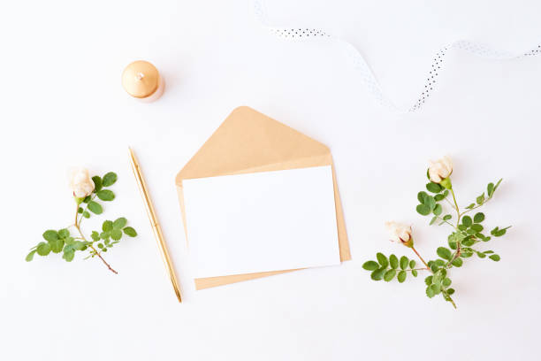 istock Mockup wedding invitation and envelope with small white flowers and green leaves on a white background 1190862465