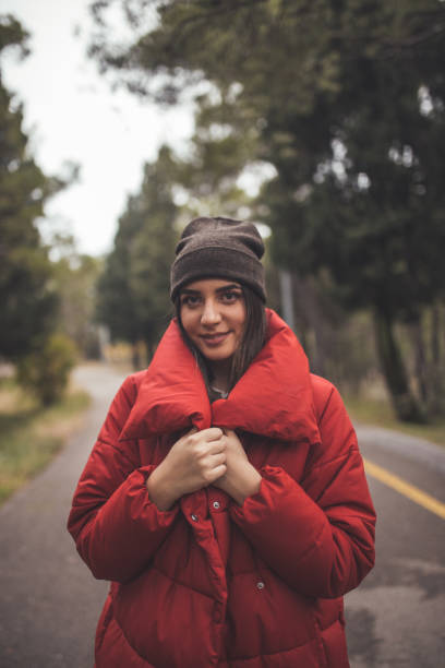 istock Beautiful young woman in red jacket posing in the forest 1190864149