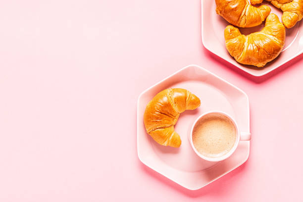 istock Coffee and croissants for breakfast on a pink background 1190865142